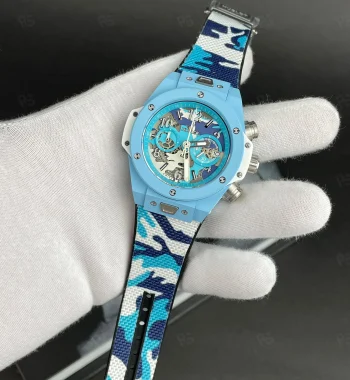 Hublot Big Bang Blue Camo, açık mavi kasalı, transparan kadranlı, kamuflaj desenli kayışlı, quartz mekanizmalı spor tarz replika saat modeli
