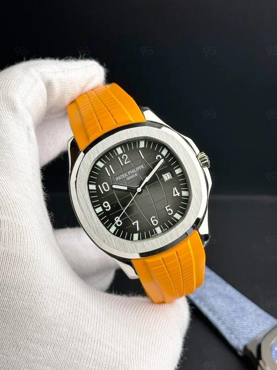 Patek Philippe Aquanaut, siyah grid desenli kadranlı, turuncu kauçuk kayışlı, çelik kasalı, otomatik mekanizmalı, ince kasalı lüks yazlık saat
