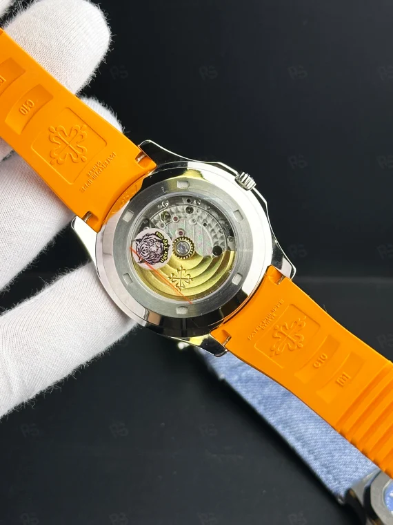 Patek Philippe Aquanaut, siyah grid desenli kadranlı, turuncu kauçuk kayışlı, çelik kasalı, otomatik mekanizmalı, ince kasalı lüks yazlık saat