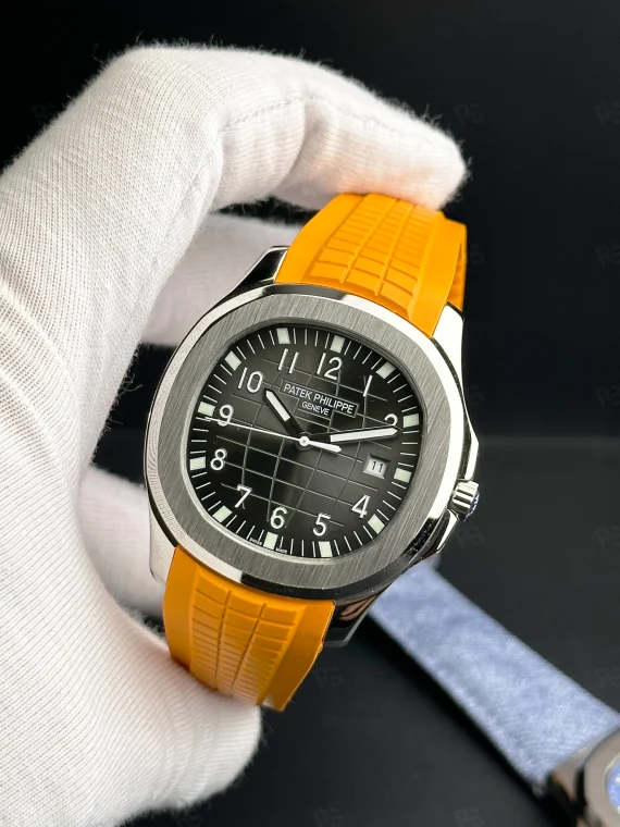 Patek Philippe Aquanaut, siyah grid desenli kadranlı, turuncu kauçuk kayışlı, çelik kasalı, otomatik mekanizmalı, ince kasalı lüks yazlık saat