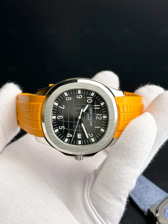 Patek Philippe Aquanaut, siyah grid desenli kadranlı, turuncu kauçuk kayışlı, çelik kasalı, otomatik mekanizmalı, ince kasalı lüks yazlık saat