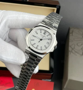 Patek Philippe Nautilus, beyaz yatay çizgili kadranlı, çelik kasalı ve bilezikli, otomatik mekanizmalı, ince kasalı lüks kol saati