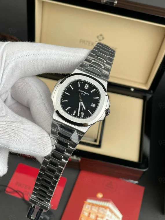 Patek Philippe Nautilus, siyah yatay çizgili kadranlı, çelik kasalı ve metal bilezikli, otomatik mekanizmalı, ince kasalı erkek saati
