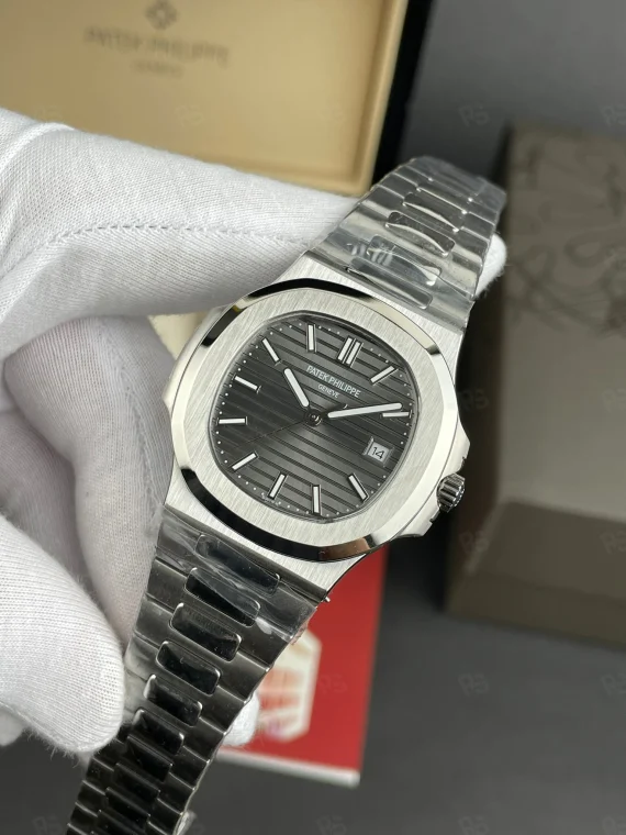Patek Philippe Nautilus, siyah-gri çizgili kadranlı, çelik kasalı ve bilezikli, otomatik mekanizmalı, ince kasalı lüks erkek saati